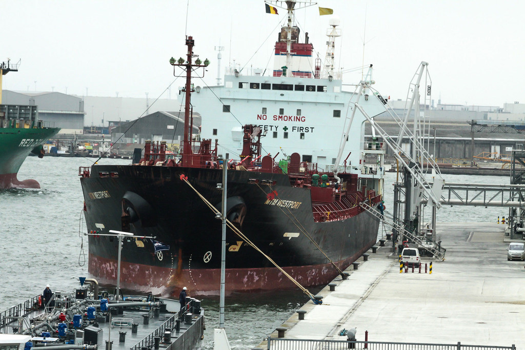 A cargo ship docked at a port in Europe.
